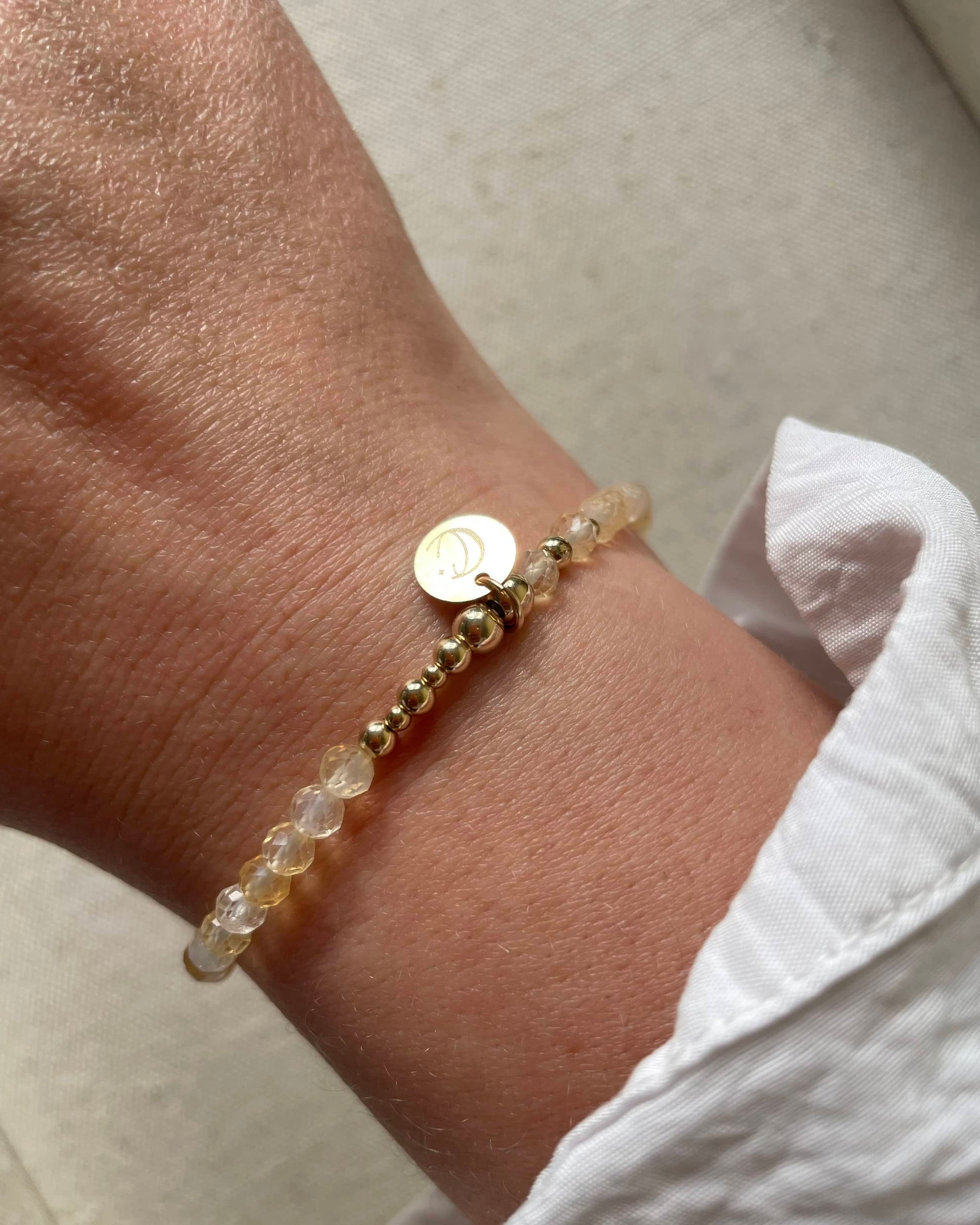 Dainty Citrine bracelet shown on wrist. Made with Citrine. Includes Star and Moon Clarity and Calm charm.